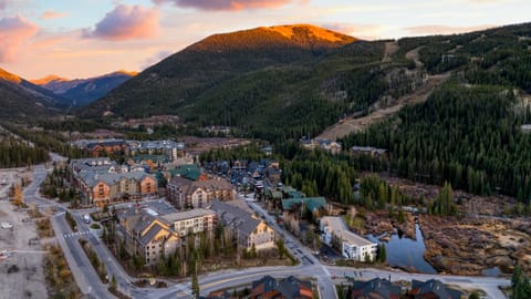 Panoramic mountain view with homes below at sunset.