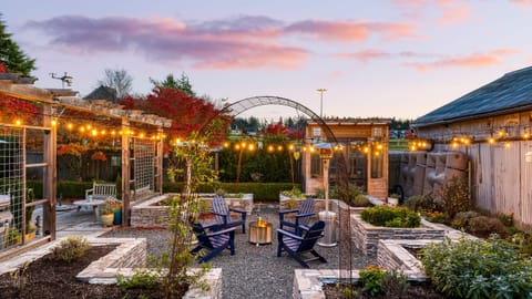 Outdoor patio with pergola and fire pit seating.