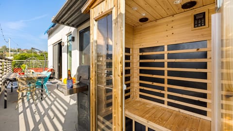 Balcony with sauna, BBQ grill, and outdoor dining table.