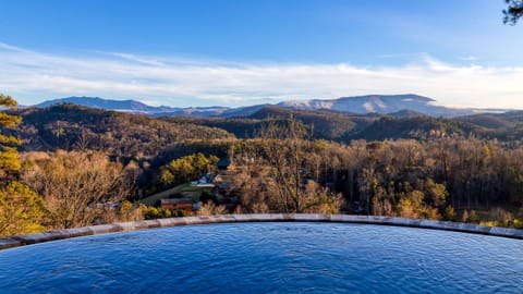 Expansive mountain panorama reflected in the infinity edge of the pool.