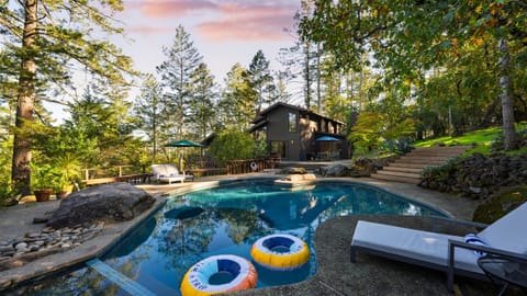 A refreshing forest escape with a sparkling pool and sun-drenched seating.