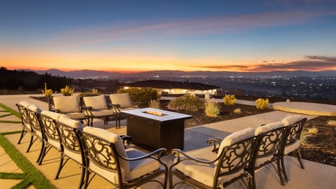 Outdoor lounge area with fire table and panoramic views.