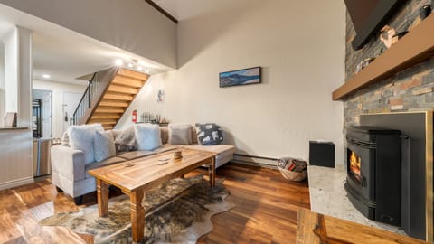 The living area features comfortable seating, a television, and a fireplace making it perfect for a cozy retreat.