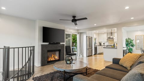 Unit 2: Cozy living room with fireplace, TV, ceiling fan, and sofa.