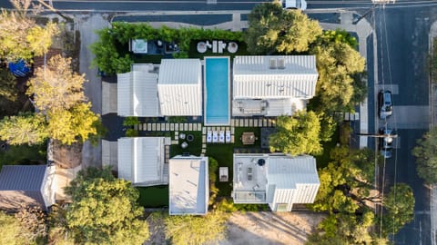 Golden-hour glow over a modern oasis with poolside lounges and cozy firepit seating.