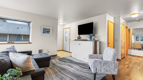 Living area view featuring a television mounted above a white cabinet and nautical decor.