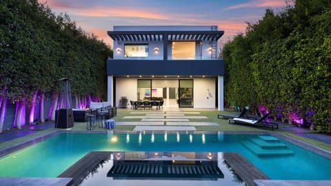 Sleek modern oasis with a private pool, lush hedged yard, and seamless indoor-outdoor living.