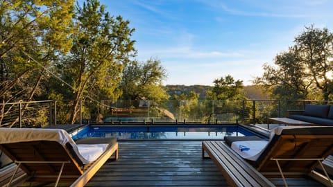 A serene pool deck framed by treetop views, perfect for soaking up the Texas sun.