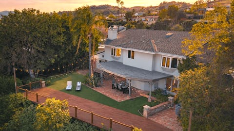Golden-hour glow at your private retreat—string lights, spacious yard, and effortless indoor-outdoor living.