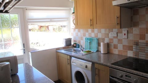 Kitchen or kitchenette, Garden view, microwave, oven, stove, washing machine