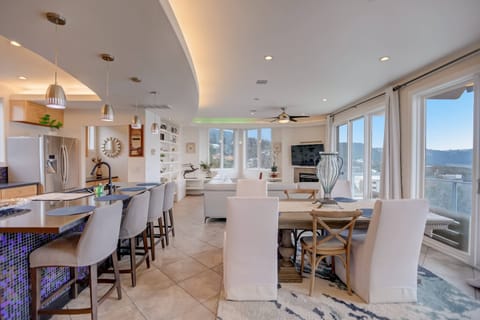 Open concept kitchen, dining and living room with bar seating and lake views