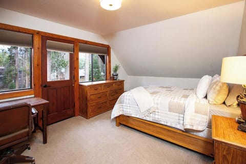 Spacious queen bedroom with desk and private balcony. 