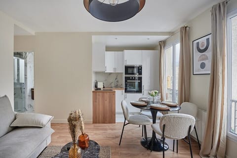 Salon avec canapé lit , cuisine américaine et coin repas