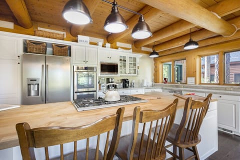Bright kitchen with bar seating and cabin-style finishes.