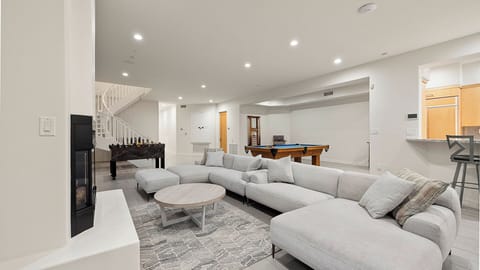 Spacious living area with fireplace, pool table, foosball, and bar.