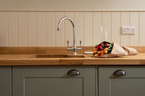 The Trouthouse - solid wood worktop and undermounted sink with characterful wall panelling above
