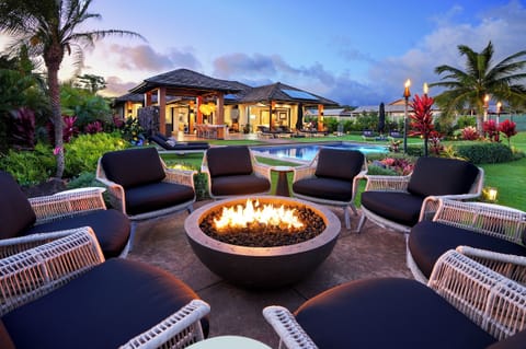 Enjoy outdoor firepit elegance, offering views of the pool and lush tropical greenery.