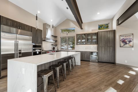 Chef's kitchen with quartz countertops and a breakfast bar with seating for 5.