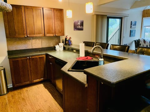 Extended part of kitchen with larger counter space and bar stools.