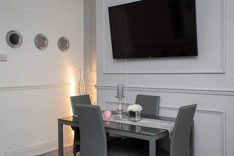 The dining table, with its sleek lines and ample seating, beckons guests to gather for memorable meals or lively conversations.