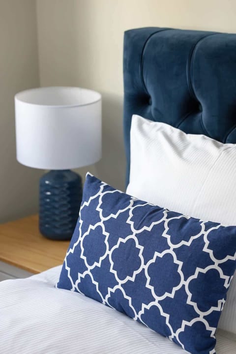 A bedside table with a lamp, adding functionality and style to the bedroom decor.

