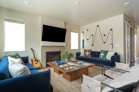 Living room with plush couches, tv, and fireplace