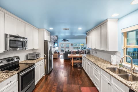 Bright and stylish, this open-concept kitchen boasts stainless steel appliances, sleek cabinetry, and everything you need to prepare meals or cocktails at home.