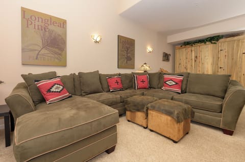 Sink into this plush sectional sofa where you can unwind with vibrant southwestern-style pillows and warm lighting for your perfect cozy evening.