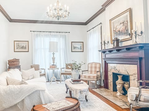 Living room adorned with plush furnishings and exquisite artwork. Natural Sun.