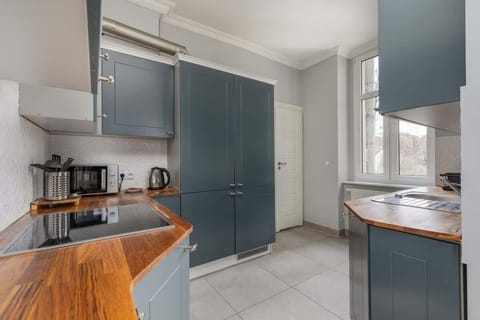Another view of the kitchen, highlighting the corner setup with a coffee station and a bright window that fills the space with natural light.

