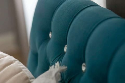 A detailed look at the tufted upholstery on the turquoise headboard, showcasing high-quality craftsmanship and luxurious design.







