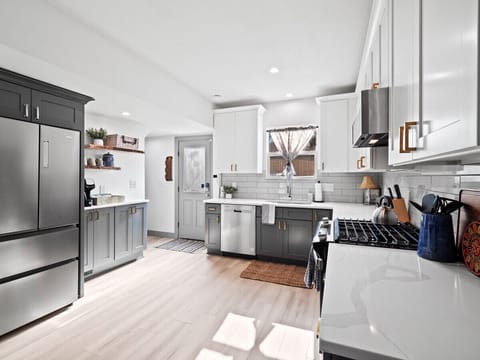 A modern kitchen adorned with Haier`s signature black cabinets, boasting sleek indoor cabinetry, a sophisticated countertop, a functional sink, and an array of cutting-edge appliances.