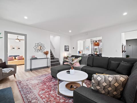 A living room adorned with a striking red rug, featuring stylish elements such as a cozy couch, a chic coffee table, and carefully curated furniture, creating a space that exudes warmth and sophistication.