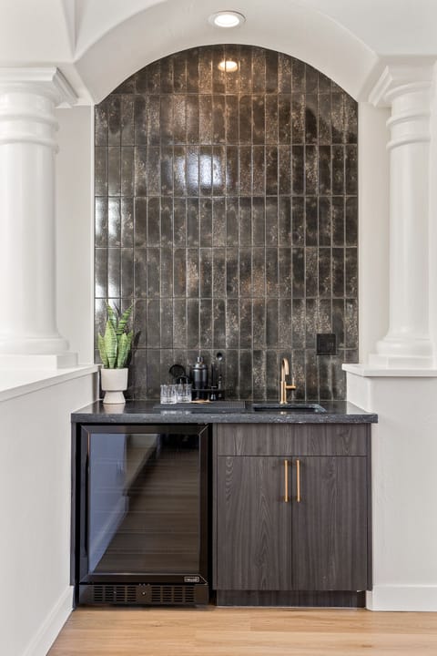 - Sedona backsplash feature with dark glossy tile accents - Modern bar area with stylish fixtures and drink essentials - Sleek design adds character to this inviting interior space