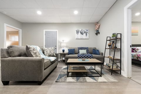 The living room features cozy furniture, ample natural light, and modern decor.