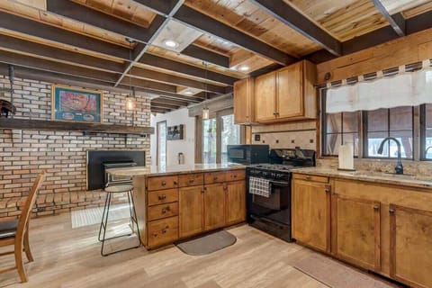 Take in the kitchen's charming setup - the stove ready for action and the fireplace adding a touch of warmth and ambiance.