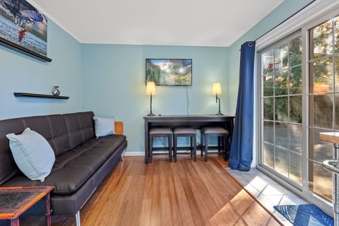 Living Room with Futon and Access to the Basketball Hoop and Outdoor Dining Space - Seating for Three (3) at Bar Style Table for Dining