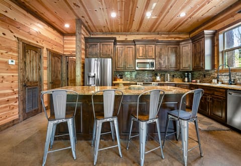 A closer view of the kitchen island and barstools highlights the kitchen's luxurious countertops