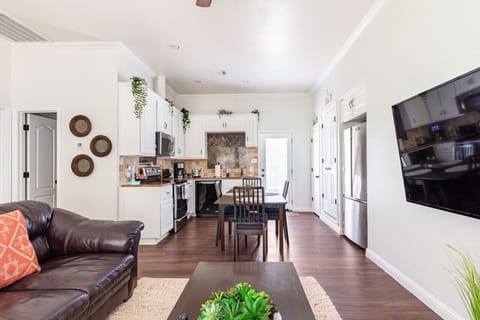 Open living area with leather sofa, 65” Smart TV, and a full kitchen — ideal for a quiet night in.