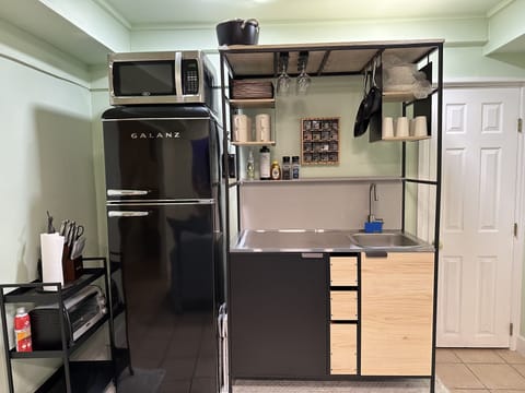 Kitchenette, with hot plate, air fryer and cooking utensils. 