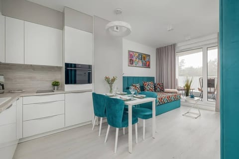 A spacious open-plan living area with a turquoise sofa, stylish decor, and modern lighting, blending luxury with comfort.







