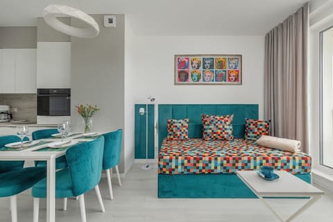 A spacious open-plan dining and living area with a turquoise and white color scheme, enhancing the modern aesthetic.

