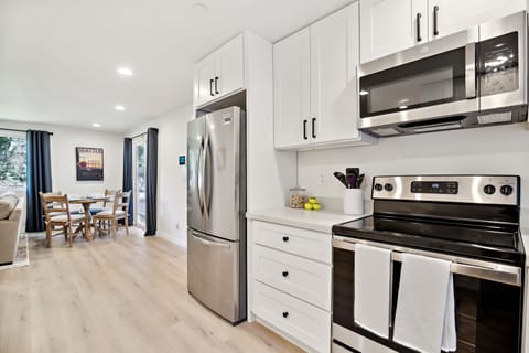 Open concept kitchen with new stainless steel appliances.