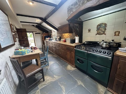 Kitchen with range of kitchen units, washing up sink, stove, dining table and chairs