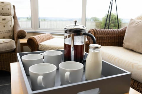 A tray in the conservatory with coffee, milk and mugs