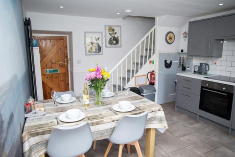 Kitchen table laid for dinner for four with a vase of flowers