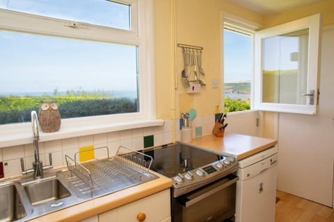 Kitchen with electric cooker and stable door leading to garden with distant sea views