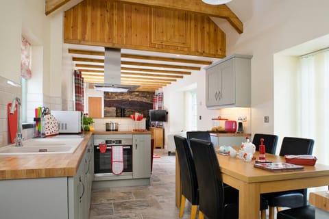 Kitchen and dining room with table and six chairs, open beamed ceiling