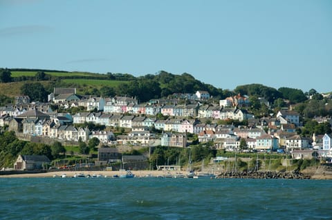 New Quay from the sea, sandy beach, moored boats and colourful houses