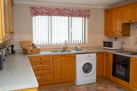 washing machine, sink under window, welcome basket, oven and microwave